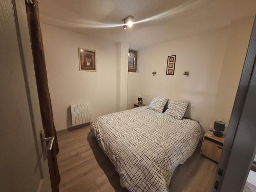 a bedroom with a bed with a checkered blanket at Au cœur de Caillassou in Villemur-sur-Tarn