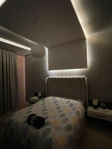 a bedroom with a bed and a light on the ceiling at Lux Apartment in Tirana