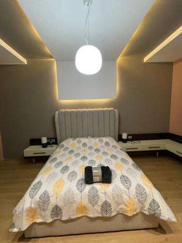 a bedroom with a bed with a camera on it at Lux Apartment in Tirana
