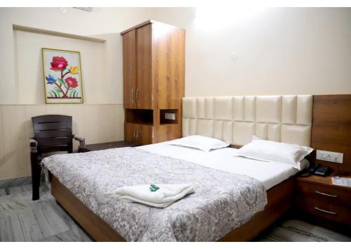 a bedroom with a bed with two towels on it at Rk Lodge in Amritsar