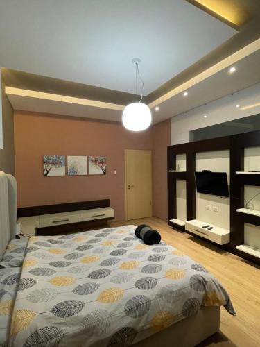 a bedroom with a large bed and a television at Lux Apartment in Tirana
