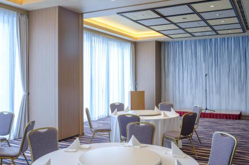 a conference room with tables and chairs and windows at Tosei Hotel Cocone Tsukiji Ginza Premier in Tokyo