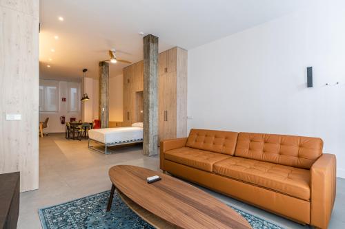 VR Palace Apartments في مدريد: غرفة معيشة مع أريكة وطاولة