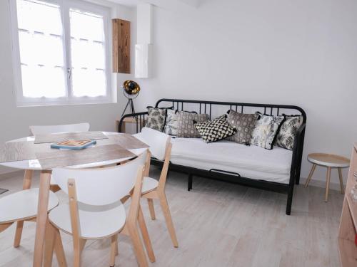 a living room with a bed and a table and chairs at Les Clématites de Saint-Aignan 4p, 7 min du Zoo in Saint-Aignan
