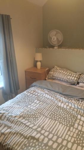 a bedroom with a bed and a lamp and a window at ACCOMADATION WREXHAM in Wrexham