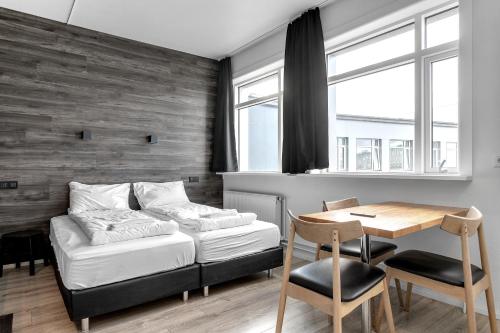 een slaapkamer met een bed, een bureau en een tafel bij Stay Apartments Bolholt in Reykjavík