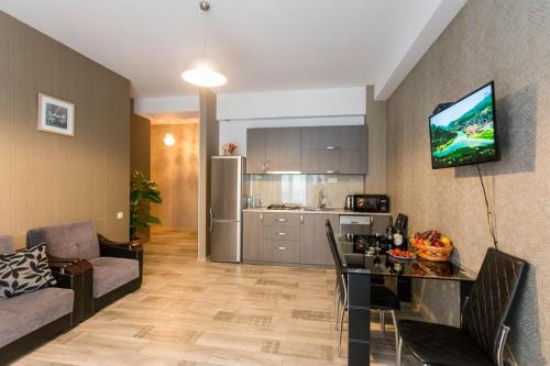 Una cocina y una sala de estar con una mesa y un sofá. en Cozy Apartment In The City Center, en Tiflis