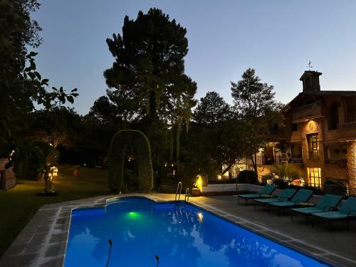 a swimming pool in front of a house at Hotel Rural Convento Santa Maria de la Sierra in Arroyo Frio
