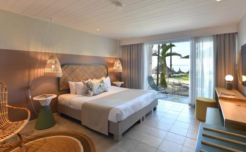 a hotel room with a bed and a balcony at Veranda Palmar Beach Hotel & Spa - All Inclusive in Belle Mare