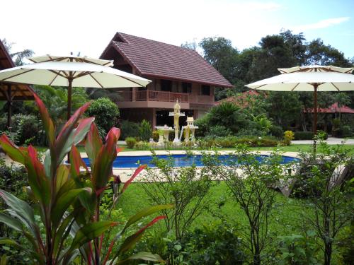 a house with a swimming pool and two umbrellas at Cliffside Lagoon Villa in Ao Nang Beach
