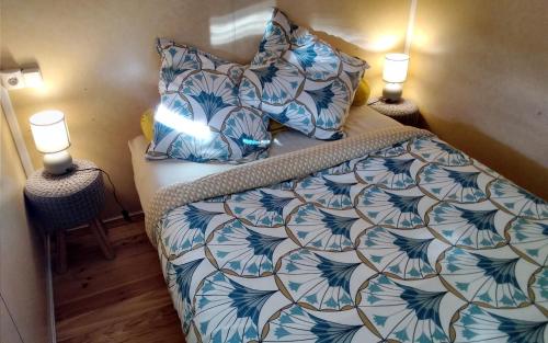 1 dormitorio con 1 cama con sábanas azules y blancas y 2 lámparas en Au Temps Suspendu - 3 chambres - Au coeur de la nature - À 10 minutes des commerces, en Vielle-Tursan