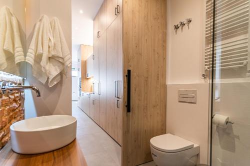 a bathroom with a white toilet and a sink at VR Palace Apartments in Madrid