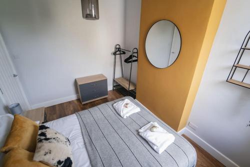 1 dormitorio con 1 cama con espejo y silla en Oldfield Apartments - Bath, en Bath