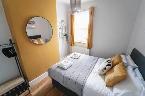 1 dormitorio con 1 cama grande y espejo en Oldfield Apartments - Bath, en Bath