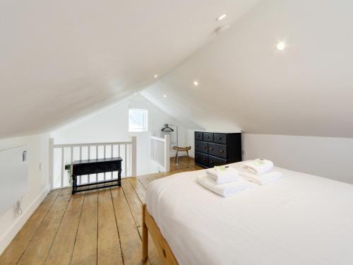 a bedroom with a white bed and a wooden floor at Pass the Keys 19th Century Barn with Free Parking in Histon