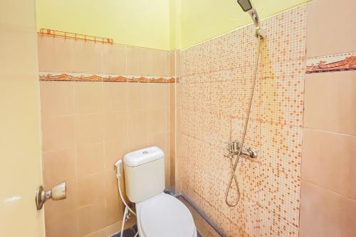 La salle de bains est pourvue d'une douche et de toilettes. dans l'établissement Sion Homestay Mitra RedDoorz near Terminal Kertajaya Mojokerto, 