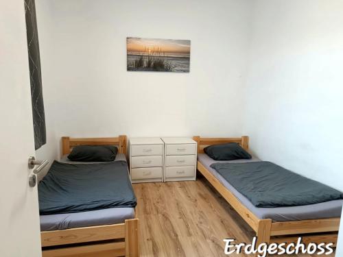 a room with two beds and a painting on the wall at APARTMENT MONTEURZiMMER AM BAHNSTEIG in Kuppenheim