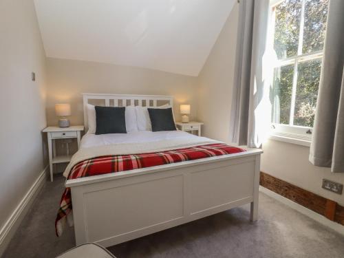 a bedroom with a white bed with two windows at The Old Post Office in Canterbury