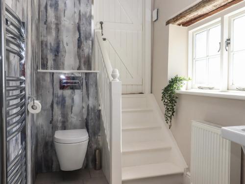 a bathroom with a toilet next to a staircase at The Old Post Office in Canterbury