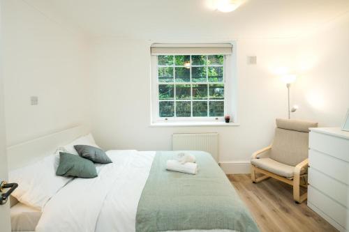 a bedroom with a bed and a chair and a window at Cozy 1 bedroom at Notting Hill in London