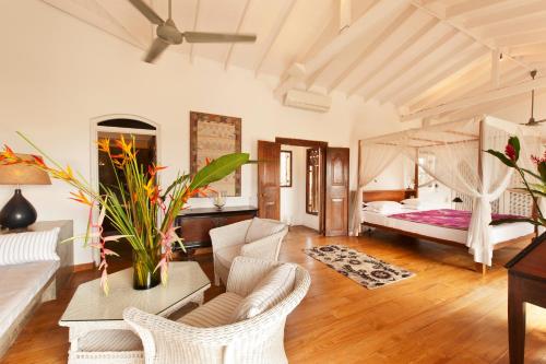 a living room with a bed and a table and chairs at A 03 Bedroom Villa in Galle Fort with Roof Terrace & Pool in Galle
