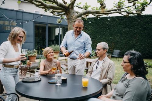 a group of people sitting around a table drinking wine at Hotel Astoria Gent in Ghent