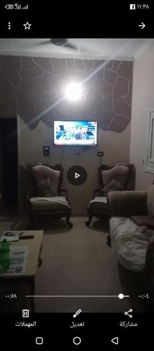 a living room with couches and a flat screen tv at سفن تورز هوستيل in Abu Simbel