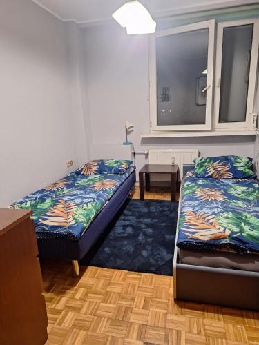 a room with two beds and a table in it at KWATERY PRACOWNICZE in Środa Wielkopolska