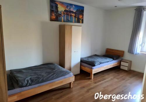 Habitación con 2 camas y armario. en APARTMENT MONTEURZiMMER AM BAHNSTEIG en Kuppenheim