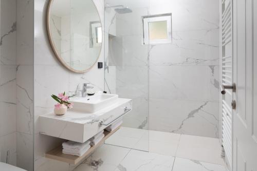 a white bathroom with a sink and a mirror at Istrian Villas Plava Laguna in Umag