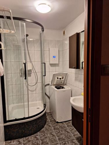 La salle de bains est pourvue d'une douche, de toilettes et d'un lavabo. dans l'établissement KWATERY PRACOWNICZE, à Środa Wielkopolska