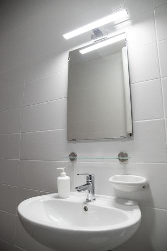 a bathroom with a white sink and a mirror at Rozmaring Apartmanház in Mórahalom