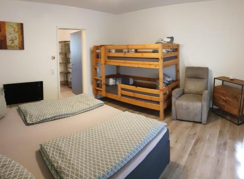 a bedroom with two bunk beds and a chair at Apartment mit 2 Zimmer im Bayerischen Wald in Sankt Englmar