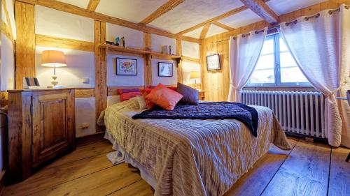 une chambre avec un lit dans une pièce avec une fenêtre dans l'établissement Remparts de Riquewihr - Le Dragon Porte-Bonheur, à Riquewihr