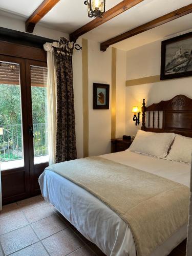 a bedroom with a large bed and a window at Hotel Rural Convento Santa Maria de la Sierra in Arroyo Frio