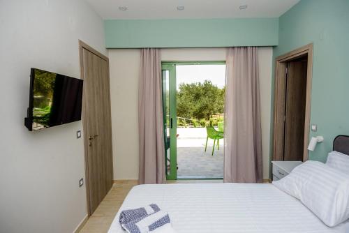 een slaapkamer met een bed, een televisie en een patio bij HELEN aparment in Argostoli