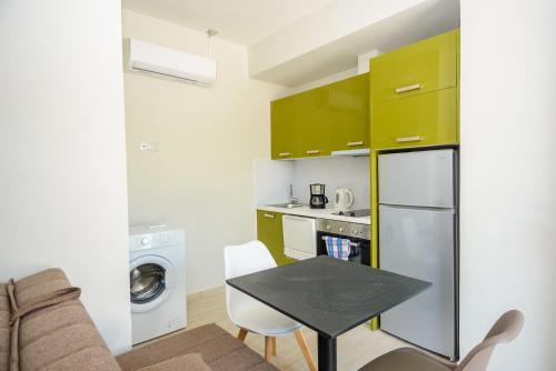 una pequeña cocina con armarios verdes y una mesa en una habitación en HELEN aparment, en Argostoli
