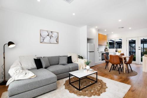 a living room with a couch and a table at Frankie's Retreat Henley Beach in Henley Beach