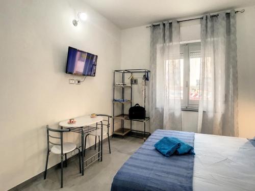 a bedroom with a bed and a table and a tv at Il Bed and Breakfast al Centro in Castelsardo