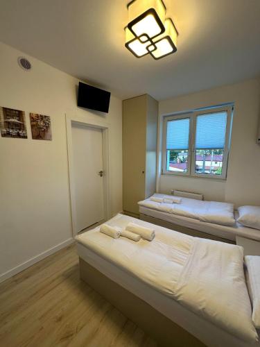 a bedroom with two beds and a window at Elbląska Noclegi in Łódź