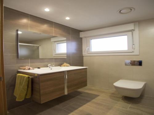 ein Badezimmer mit Waschbecken, Toilette und Spiegel in der Unterkunft Apartamento Rural La Patxuela in Obanos