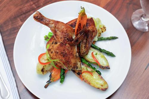 a white plate with chicken and vegetables on a table at DoubleTree by Hilton Hotel Newark Airport in Newark