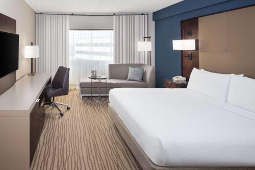 a hotel room with a large bed and a desk at DoubleTree by Hilton Hotel Newark Airport in Newark