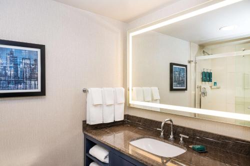 bagno con lavandino e grande specchio di DoubleTree by Hilton Hotel Newark Airport a Newark
