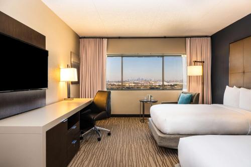 a hotel room with a bed and a flat screen tv at DoubleTree by Hilton Hotel Newark Airport in Newark
