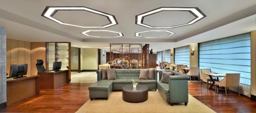 a lobby with a couch and chairs and a table at JW Marriott Hotel New Delhi Aerocity in New Delhi