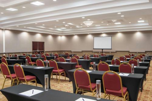 a conference room with tables and chairs and a screen at DoubleTree by Hilton Hotel Newark Airport in Newark