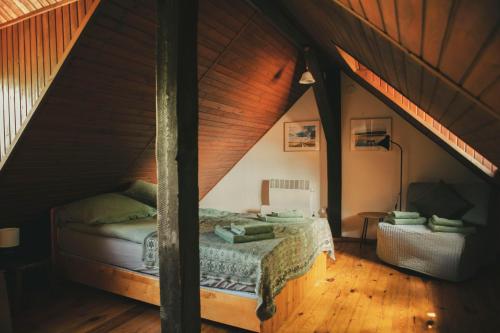 a bedroom with a bed in a attic at Stara Kuźnia- Domek w Puszczy Noteckiej in Zatom Nowy