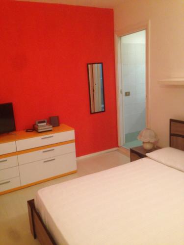 雷焦艾米利亞的住宿－punto G，一间卧室设有两张床和红色的墙壁