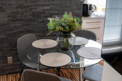 a glass table with chairs and a vase with flowers at Beautiful Apartments With Parking In a Quiet Location in Ostrava